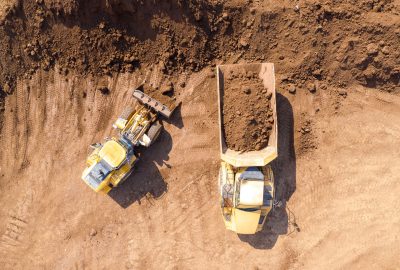 Excavator loading soil onto an Articulated hauler Truck, Top dow